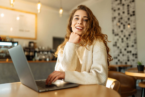 Young woman with laptop at home. Freelance, online course, remote work and lifestyle concept. Online shopping with laptop - 写真・画像