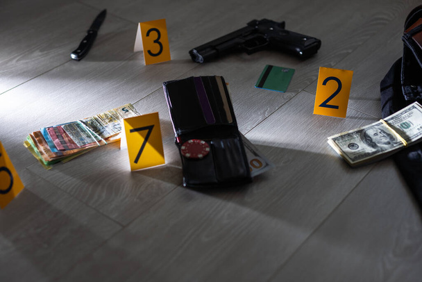 Concepto de investigación de la escena del crimen Pistola y bala contra el marcador amarillo del crimen en el piso del apartamento. Foto de alta calidad - Foto, Imagen