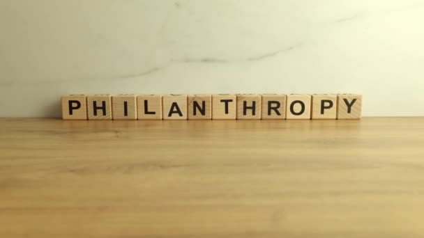 Filantropisch woord van houten blokken op bureau - Video