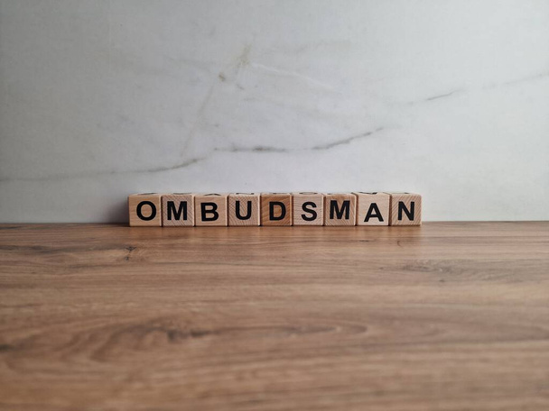 Ombudsman woord uit houten blokken op Bureau - Foto, afbeelding