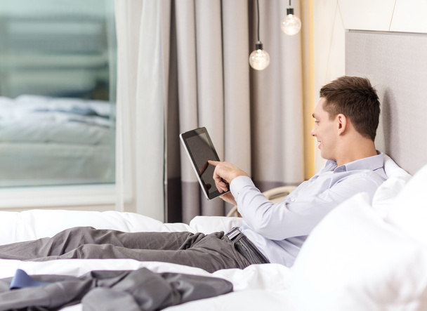 happy businesswoman with tablet pc in hotel room - Photo, Image
