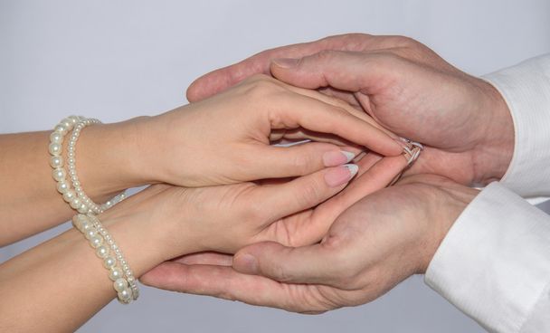 Female hand in caring man hands - 写真・画像