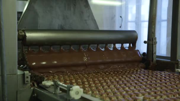 statyczny średni strzał nalewania cukierków czekoladą w fabryce czekolady na linii przenośnika - Materiał filmowy, wideo