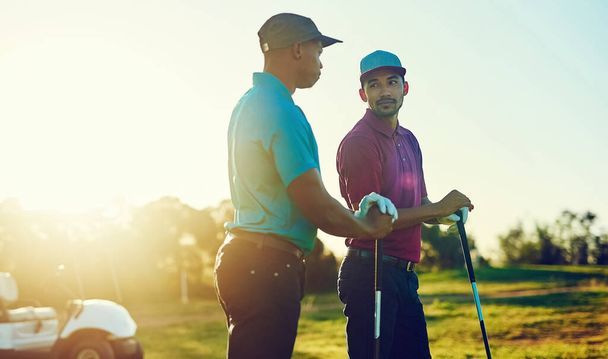 Враги на поле, друзья вне его. двое друзей играют в гольф на поле для гольфа - Фото, изображение