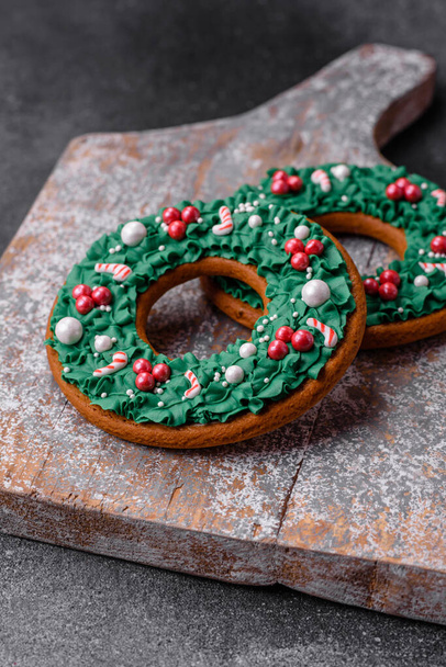 Вкусное красивое рождественское пряничное печенье на текстурированном бетонном фоне в качестве украшения праздничного новогоднего стола - Фото, изображение