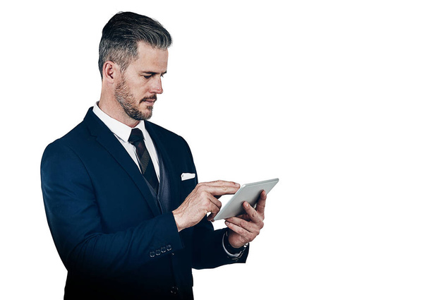 His tool of choice for maximized productivity. Studio shot of a businessman using a digital tablet against a white background - Photo, Image