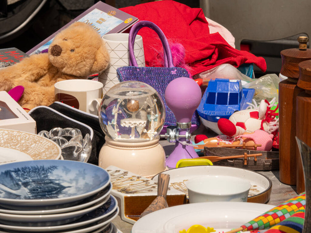 Játékok gyerekeknek és tányérok jelenik meg az asztalon a bolhapiacon. - Fotó, kép