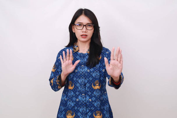 Asian female in batik korpri, indonesian traditional uniform making rejection hand gesture - Photo, Image
