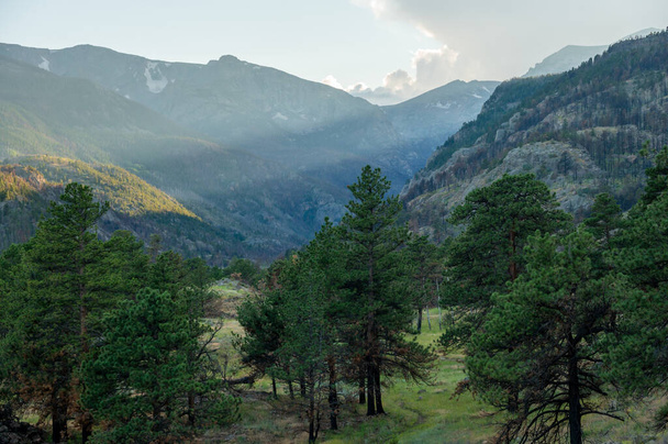 Evening LIght Breaks Through the Peaks Of Rocky Mountain National Park - Photo, Image