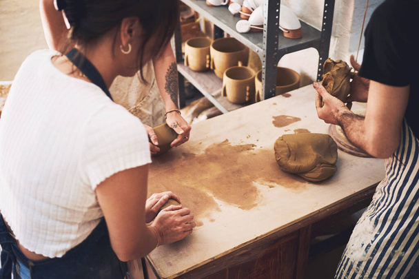 Theres always more to explore when it comes to clay. a young woman kneading clay in a pottery studio - Фото, изображение