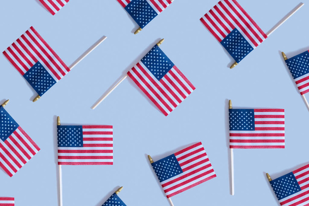 Μοτίβο από τις ΗΠΑ σημαίες πάνω άποψη, επίπεδη θέσει σε μπλε φόντο. Έννοια ημέρα ανεξαρτησίας - Φωτογραφία, εικόνα