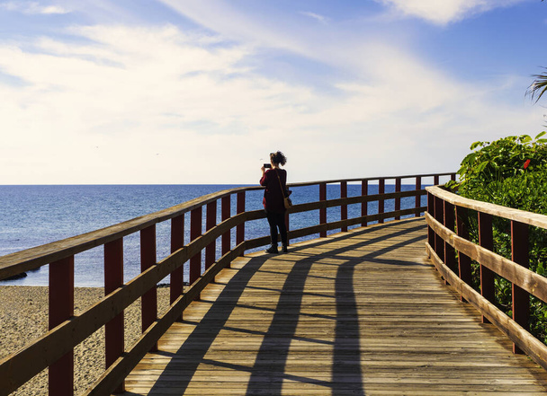 young woman walking on a pier  - Фото, зображення