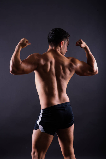 Muscular shirtless young man standing confident, front view, looking at a camera - Foto, Bild