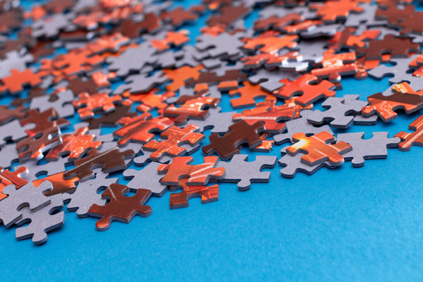 Mixed Peaces of a Colorful Jigsaw Puzzle Lie on the Blue Background - Strategy and Solving Problem Concept - Photo, Image