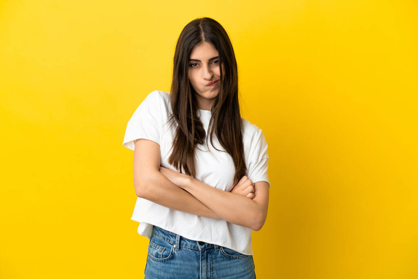 Young caucasian woman isolated on yellow background with unhappy expression - Foto, Bild