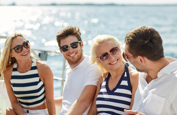 smiling friends sitting on yacht deck - Fotografie, Obrázek