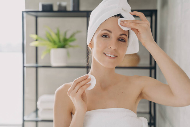Cuidado de la piel personal de la mujer: hidratante, limpieza de la piel facial con almohadillas de algodón en el baño - Foto, Imagen