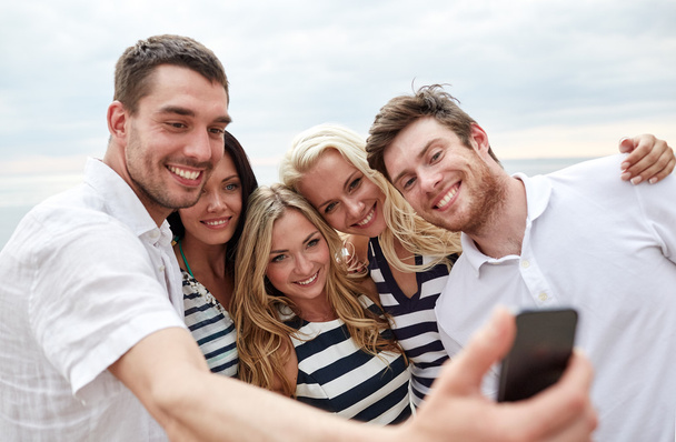happy friends on beach and taking selfie - Foto, Imagem