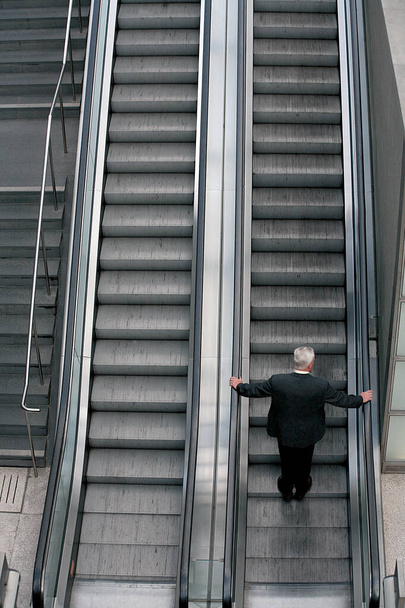 Άνθρωπος στις κυλιόμενες σκάλες. Άνθρωπος στις κυλιόμενες σκάλες. - Φωτογραφία, εικόνα
