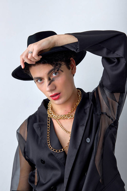 Face portrait of glamorous gay man 20s wear black shirt and stylish hat, make-up looking at camera isolated on white background studio. Homosexual lgbtiq concept. fashion, style, chic, pageantry - Φωτογραφία, εικόνα