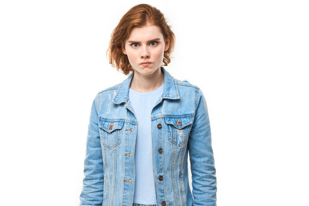 Πορτρέτο θυμωμένος κοκκινομάλλα νεαρή γυναίκα απομονώνονται σε λευκό φόντο στούντιο, δείχνουν αρνητικά συναισθήματα - Φωτογραφία, εικόνα