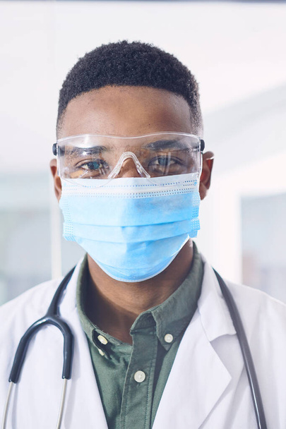 I always put safety first. Cropped portrait of a handsome young male doctor wearing a mask and goggles while standing in the hospital - Foto, Bild
