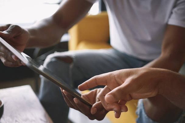 Давайте поширювати це слово у соціальних мережах. двоє молодих чоловіків використовують цифровий планшет, сидячи разом у кав'ярні
 - Фото, зображення