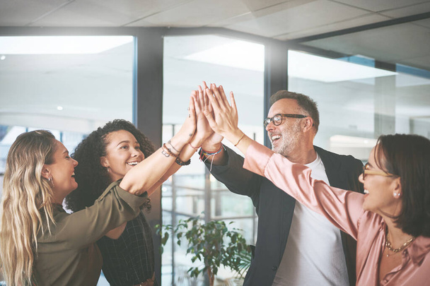 My team is capable of everything. a diverse group of businesspeople giving each other a high five during a meeting in the office - Фото, зображення