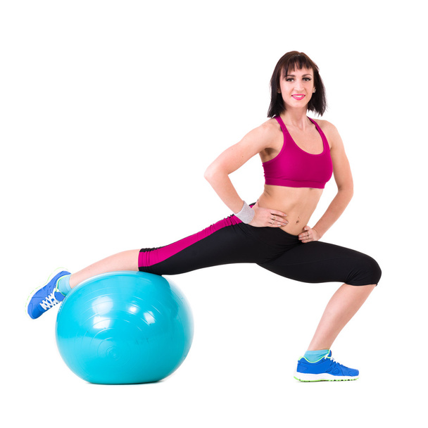 Νεαρή χαμογελαστή γυναίκα κάνει άσκηση με fitball - Φωτογραφία, εικόνα