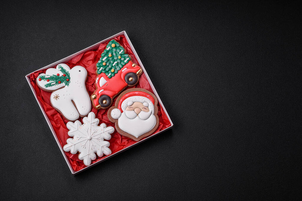 Frisch lecker gebackene Weihnachts- oder Neujahrskekse mit hellen Farbmustern auf dunklem Betonhintergrund - Foto, Bild