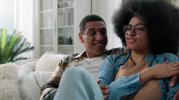 African American ευτυχισμένη οικογένεια ζευγάρι στην αγάπη σύνδεση αγάπη μιλάμε επικοινωνούν συζήτηση συζήτηση casual μιλώντας χαμογελώντας μοιραστείτε ειδήσεις αγόρι και η κοπέλα γυναίκα στο σπίτι καναπέ καναπέ - Πλάνα, βίντεο