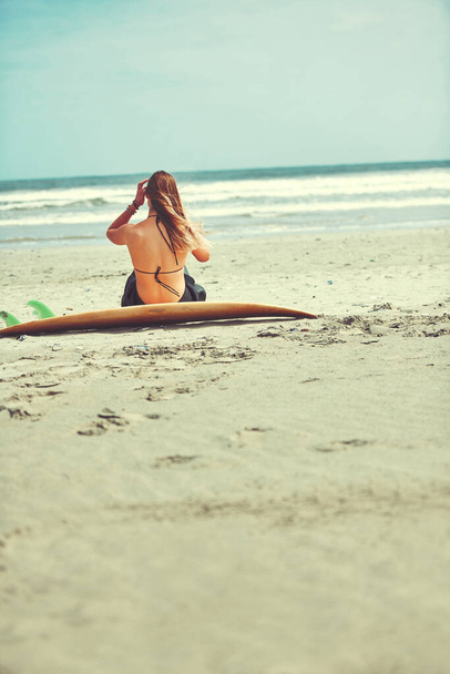 El surf siempre es una buena idea. una hermosa joven que va a surfear en la playa - Foto, Imagen