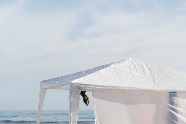 White gazebo on the beach with the sea in the background. - Fotoğraf, Görsel