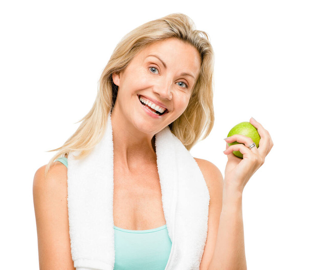 Portret, ćwiczenia i jabłko ze starszą kobietą w studiu odizolowaną na białym tle dla zdrowia. fitness, dieta i styl życia ze szczęśliwą dojrzałą sportowczynią jedzącą owoce na odżywianie. - Zdjęcie, obraz