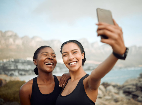 Fitness friends laugh in selfie at beach, women workout together with happiness and active life outdoor. Exercise in nature, healthy and happy with female people training and smile in picture or post. - Foto, Imagem