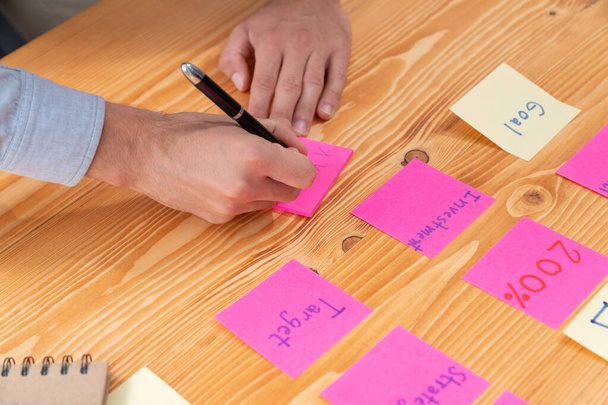 Obchodní tým shromáždit na stole, brainstorming a psaní kreativní nápad na barevné post-it poznámky. Strategie plánování a brainstorm k dosažení obchodních cílů. horlivý - Fotografie, Obrázek