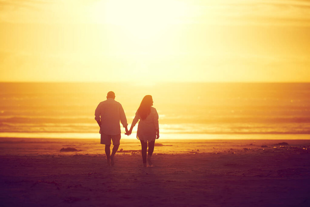 Ill always be by your side. Rearview shot of an affectionate mature couple walking hand in hand on the beach - Foto, Imagem