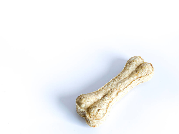 Cão mastigar bastão de osso no fundo branco - Foto, Imagem
