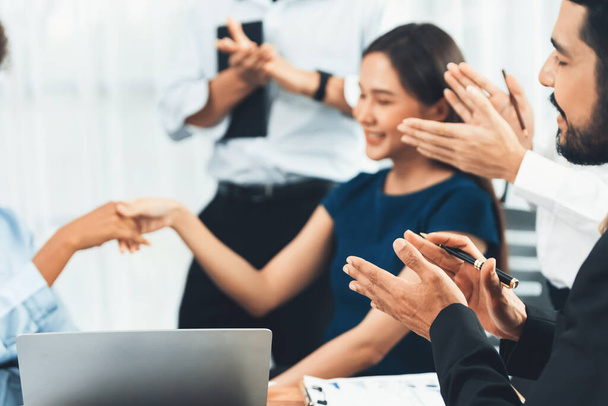 Diverse coworkers celebrate success with handshake and teamwork in corporate workplace. Multicultural team of happy professionals united in solidarity by handshaking in office. Concord - 写真・画像