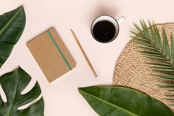 Tropical workspace concept. Notepad and tropical palm leaves. Mockup presentation workplace - Photo, Image