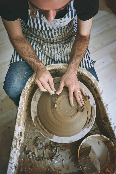 Musisz to oddać jego technice garncarskiej. człowiek pracujący z gliną w pracowni garncarskiej - Zdjęcie, obraz