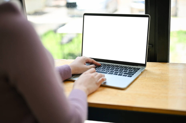 Közelkép egy nőről, aki a kávézó laptopját használja. laptop fehér képernyő mockup - Fotó, kép