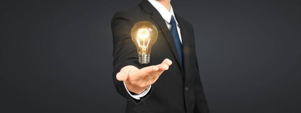 Люди держат лампочки в руке инновационных технологий и творчества - Фото, изображение
