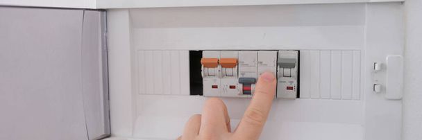 Turning on the circuit breaker on control panel after it tripped due to overload. Circuit breaker concept - Foto, imagen