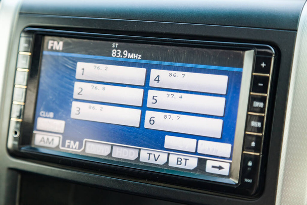車内のパネルの中央制御コンソールには、コンピュータディスプレイ、オーディオシステム、グレーとブラックのプラスチック製のラジオが付いています。オンボードナビゲーター画面. - 写真・画像