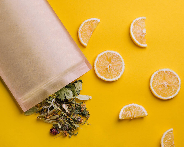 Paper bag with dry loose leaf tea with lemon slices - Foto, Imagem