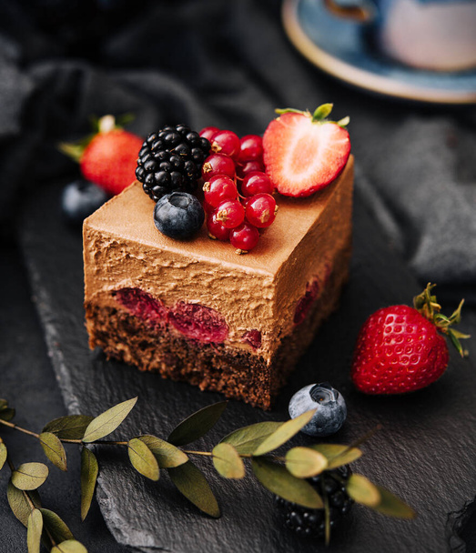 Delicioso bolo de chocolate decorado com bagas frescas na mesa preta de pedra - Foto, Imagem