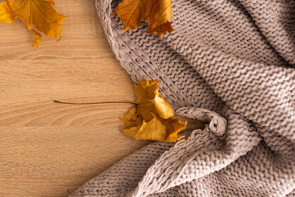Autumn background with a plaid and with yellow leaves. - Photo, Image