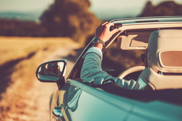 Καυκάσιος επιτυχημένος οδηγός απολαμβάνοντας το καλοκαίρι οδικό ταξίδι στο σύγχρονο Cabriolet του. Κομψό μετατρέψιμο αυτοκίνητο - Φωτογραφία, εικόνα