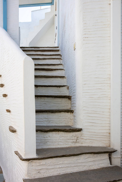 White painted old narrow stair background covered with stone between white wall. Small exterior step. Cyclades island architecture, Greece. Vertical - Φωτογραφία, εικόνα